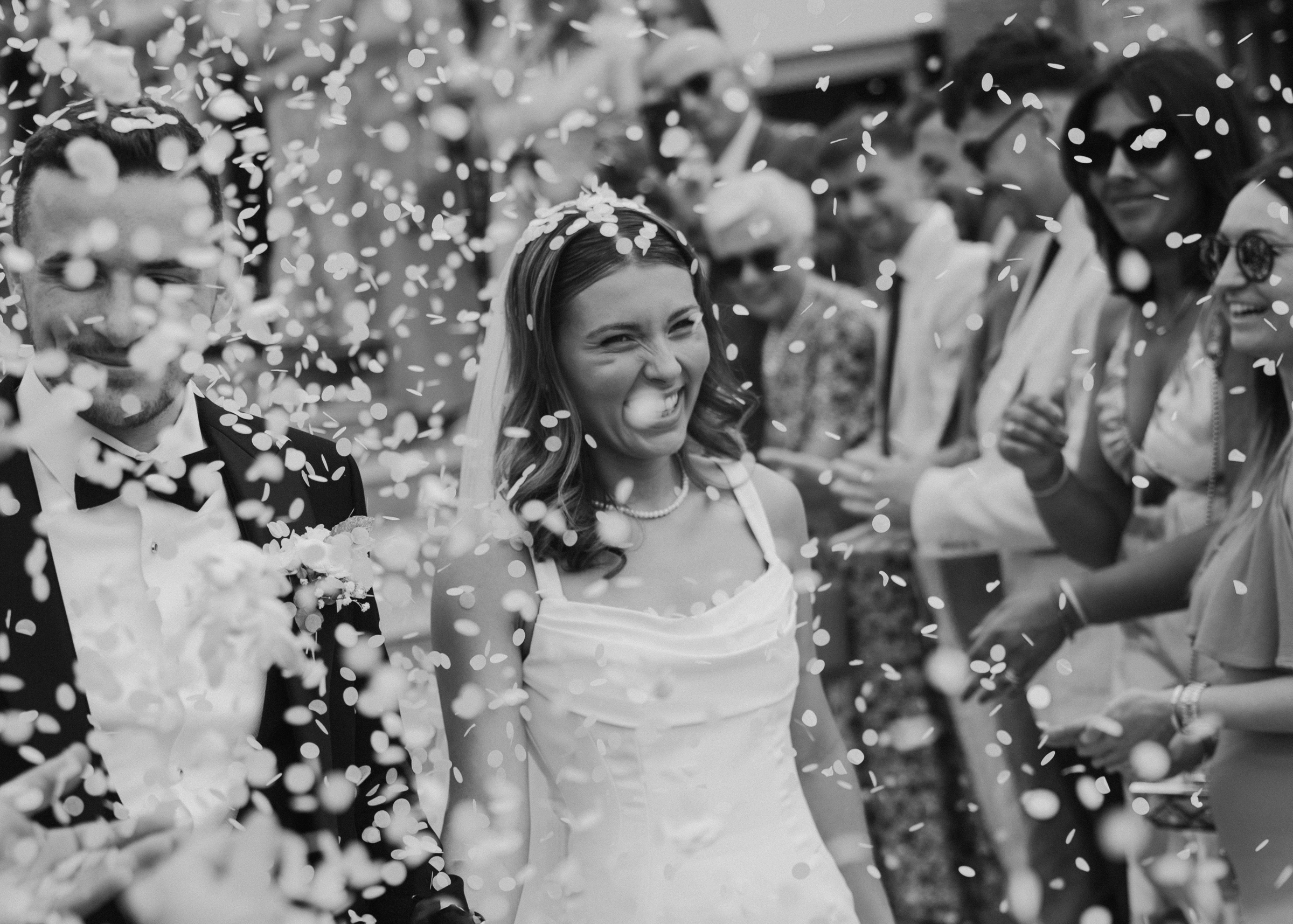 A joyful confetti moment outside a wedding ceremony