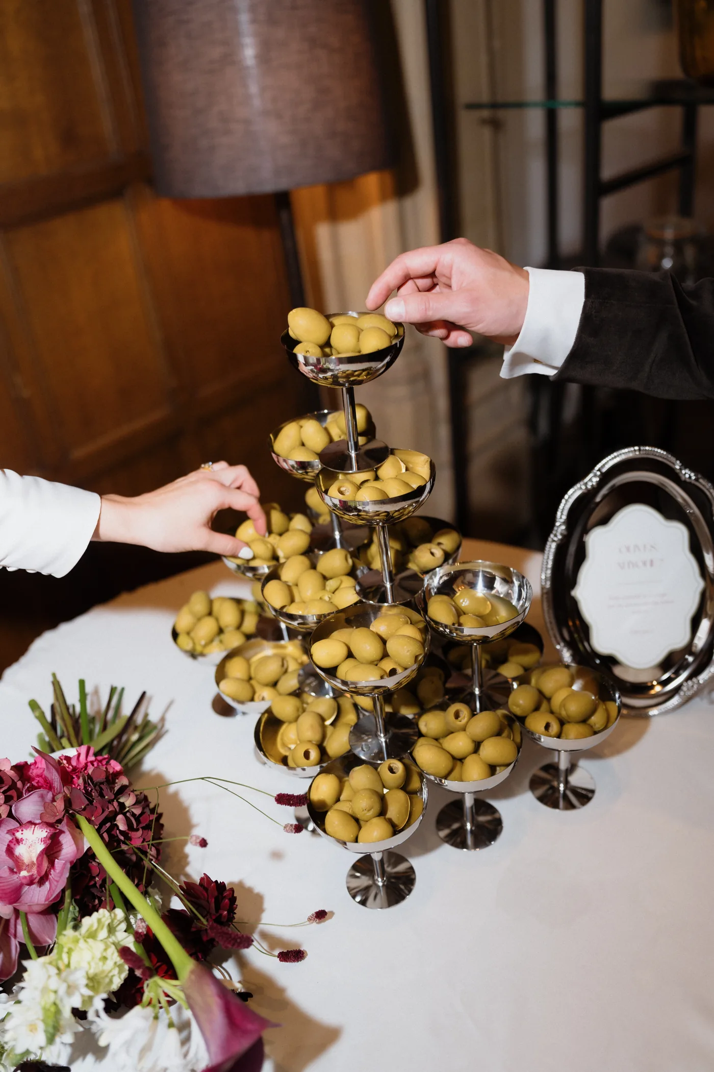 Guests adding olives to a champagne tower