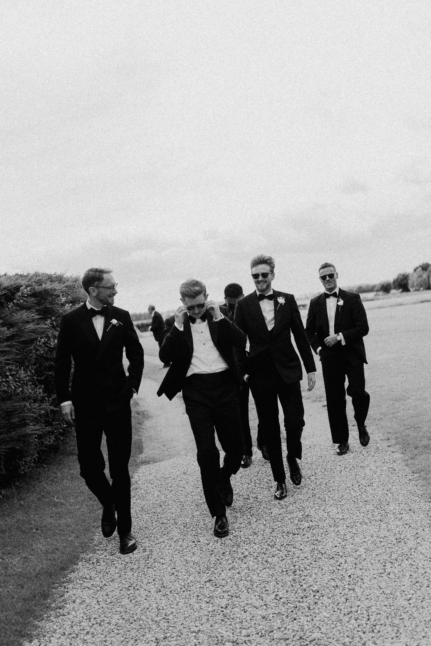 Black-and-white photograph of the groom and groomsmen walking together