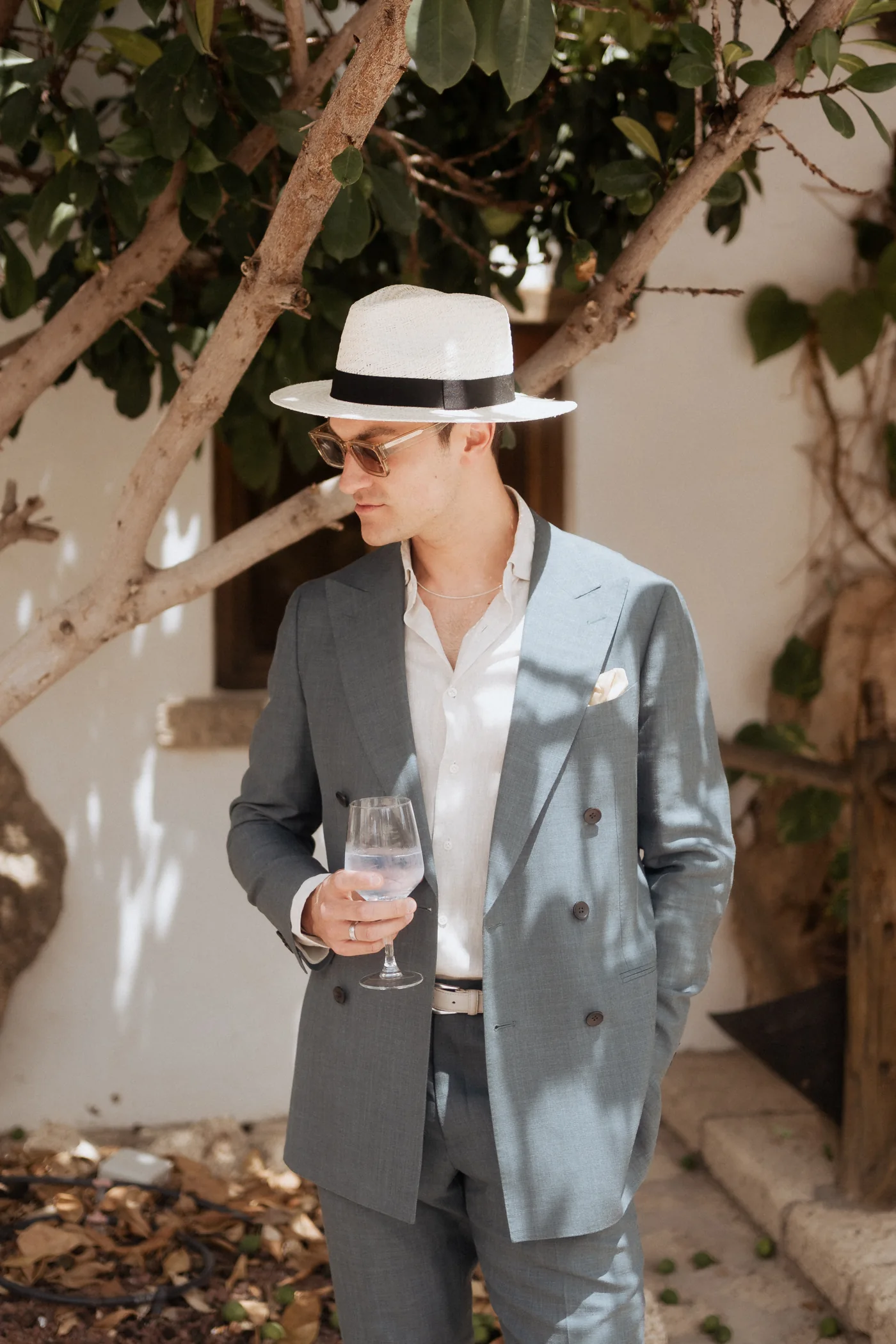 Wedding guest wearing a pale suit and Panama hat